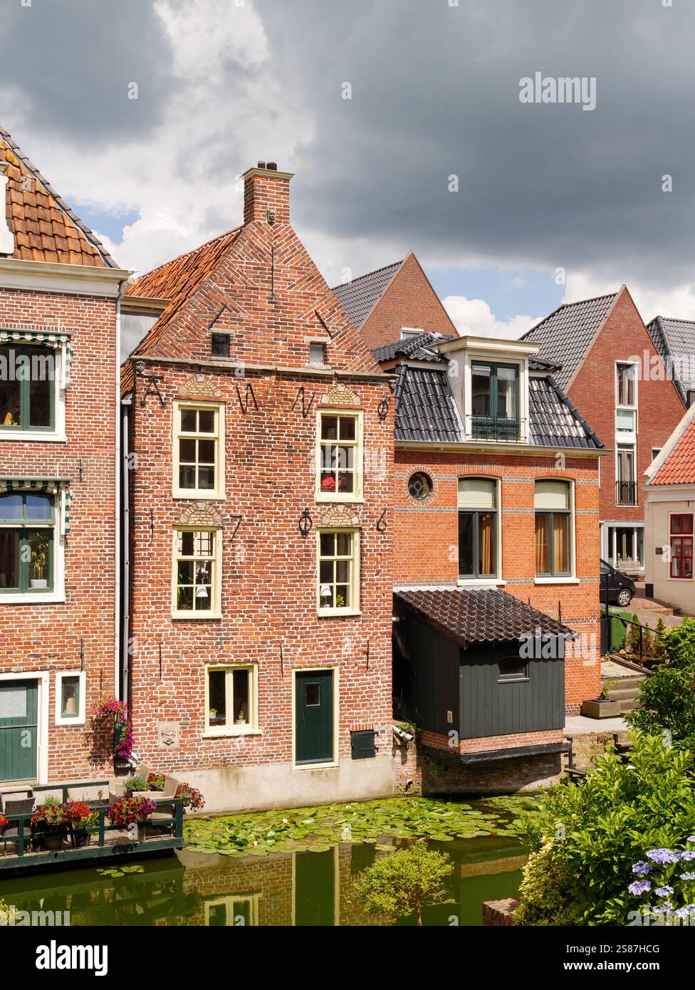 Kanalhäuser mit hängenden Küchen über dem Damsterdiep-Kanal in der historischen Stadt Appingedam, Eemsdelta, Groningen, Niederlande Stockfoto
