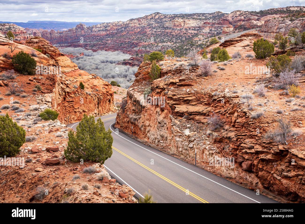 Eine kurvenreiche Straße in Utah zieht sich durch eine atemberaubende felsige Landschaft mit scharfen Kurven und steilen Steigungen. Stockfoto