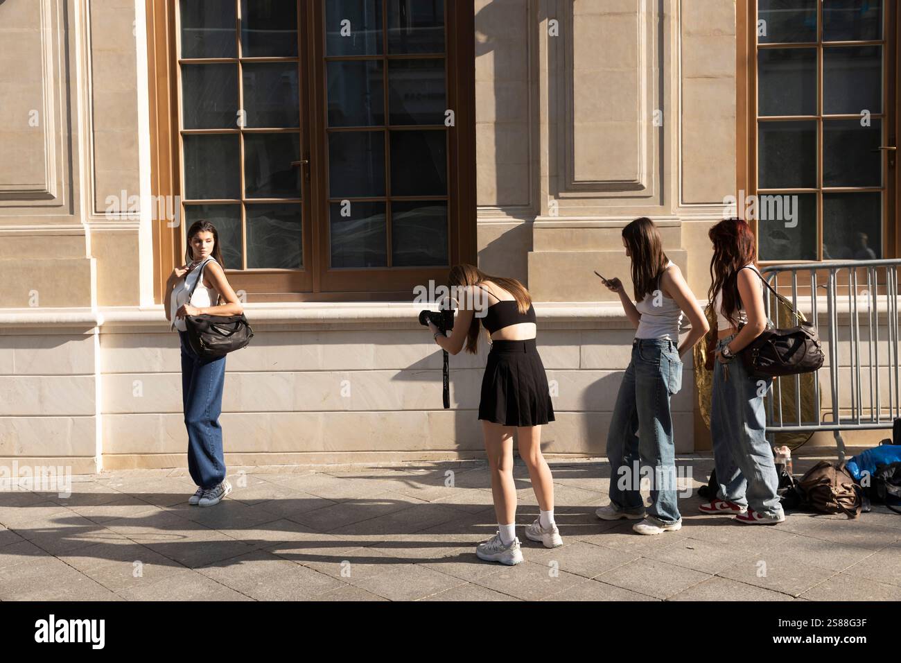 Moskau, Russland - am 25. August 2024 macht Ein Fotograf Fotos von einem Mädchen. Ihre Freunde drehen Rollen. Das Mädchen posiert vor einem Stockfoto