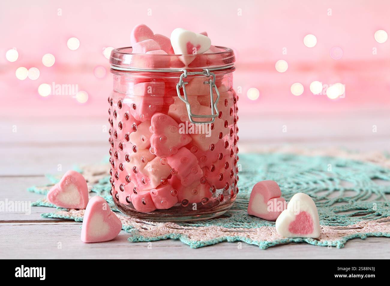 Rosafarbenes Glas gefüllt mit Herzmarshmallows Stockfoto