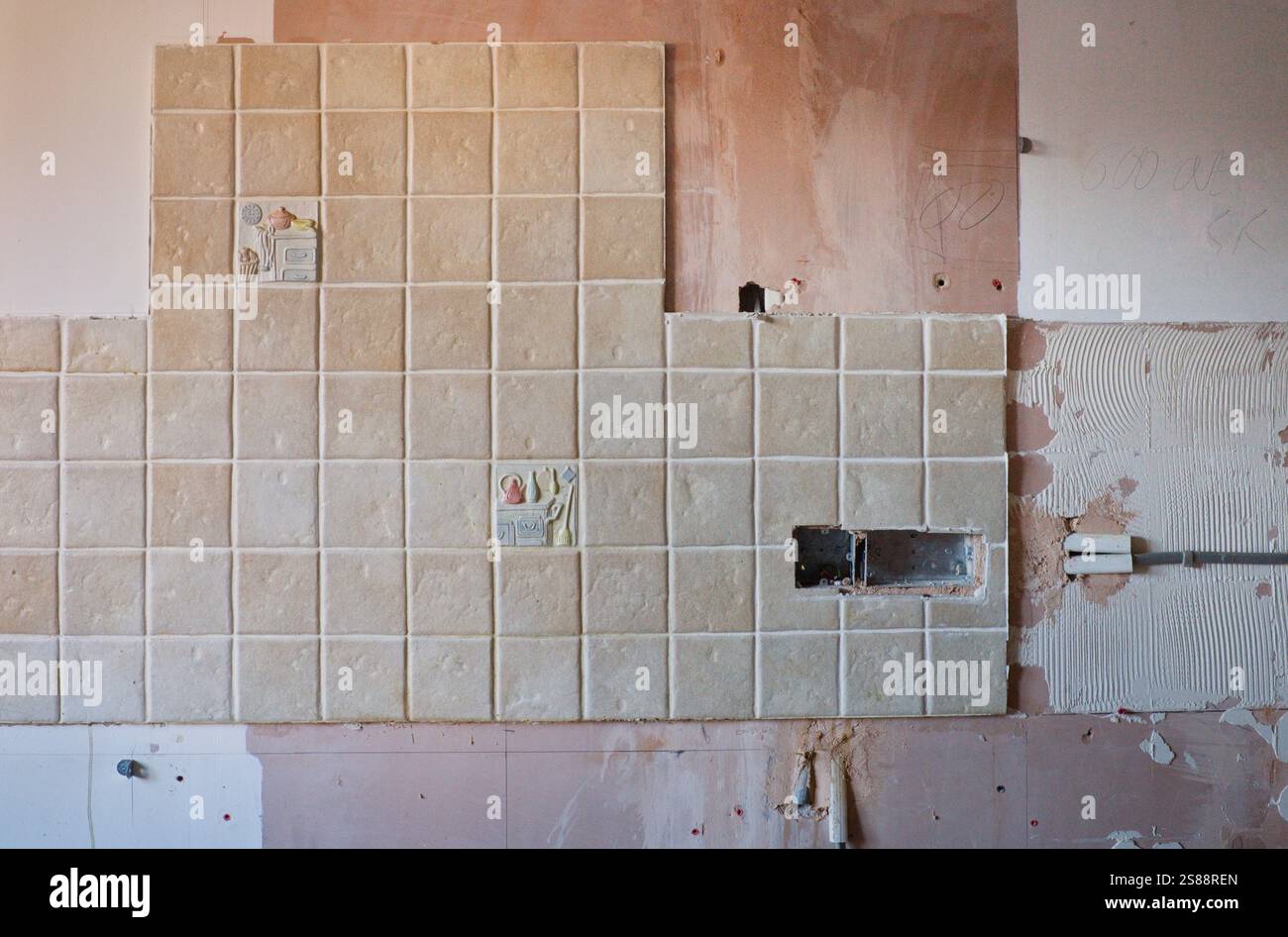 Wand mit alten Küchenfliesen halb abgenommen Stockfoto