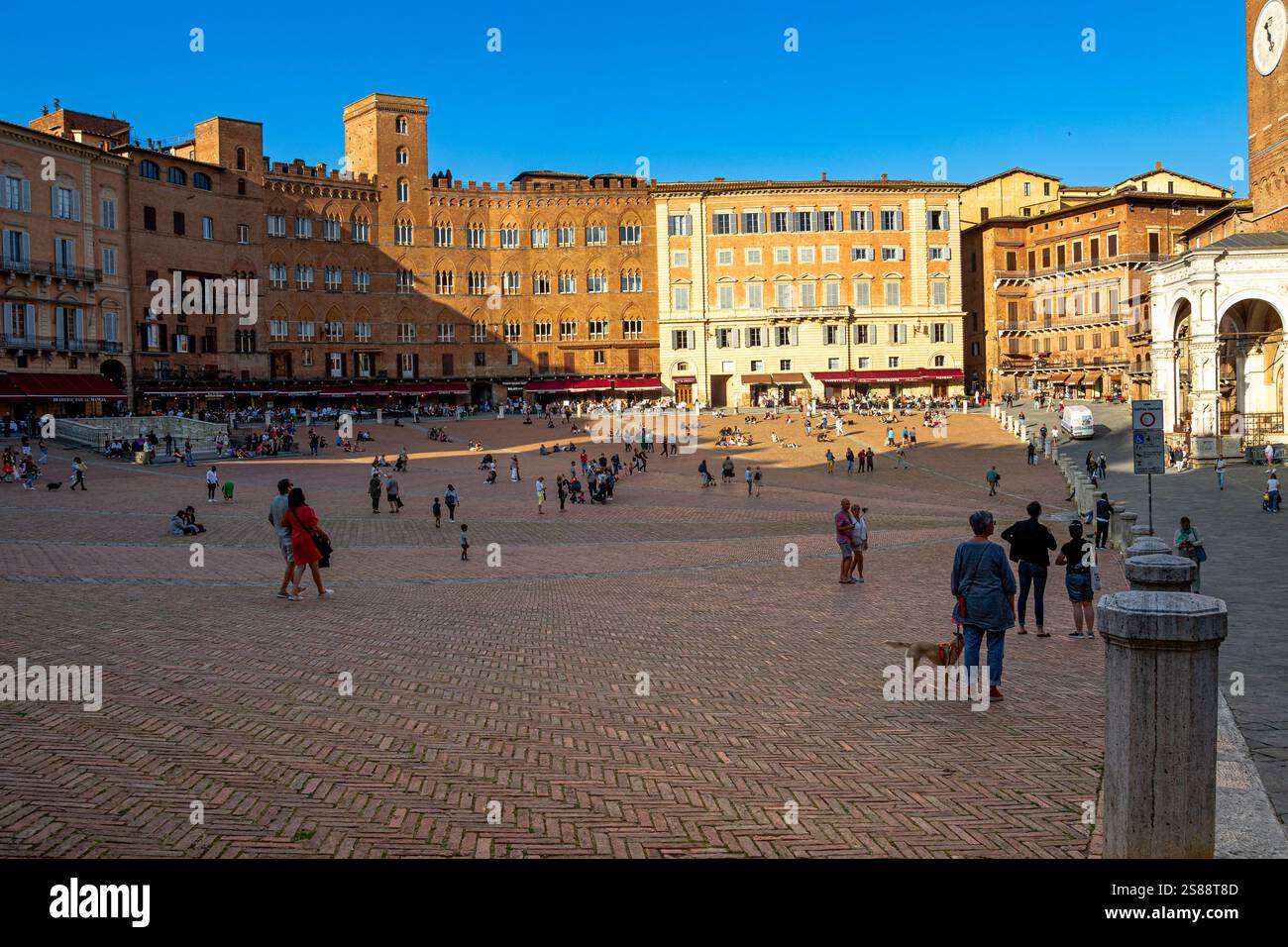Menschen auf der Piazza del Campo, dem wichtigsten öffentlichen Platz im historischen Zentrum von Siena in Italien, der weithin als einer der größten mittelalterlichen Plätze Europas gilt Stockfoto
