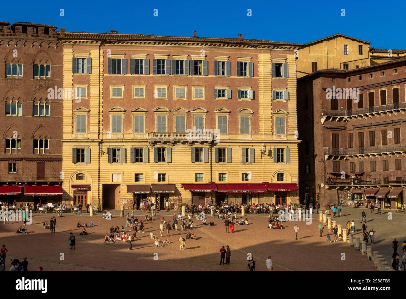 Menschen auf der Piazza del Campo, dem wichtigsten öffentlichen Platz im historischen Zentrum von Siena in Italien, der weithin als einer der größten mittelalterlichen Plätze Europas gilt Stockfoto