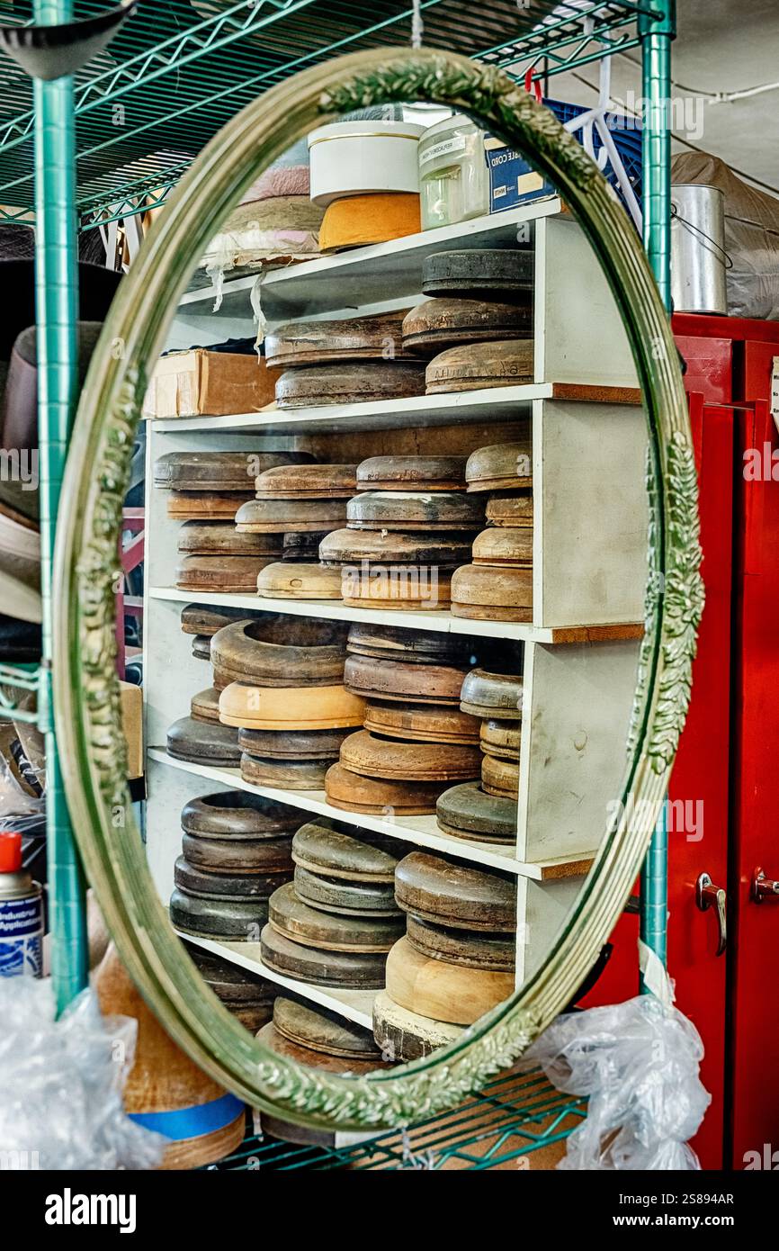 Ein Spiegel in einer Hutfabrik zeigt ein Spiegelbild von Regalen, die mit Hutformen gefüllt sind. Stockfoto