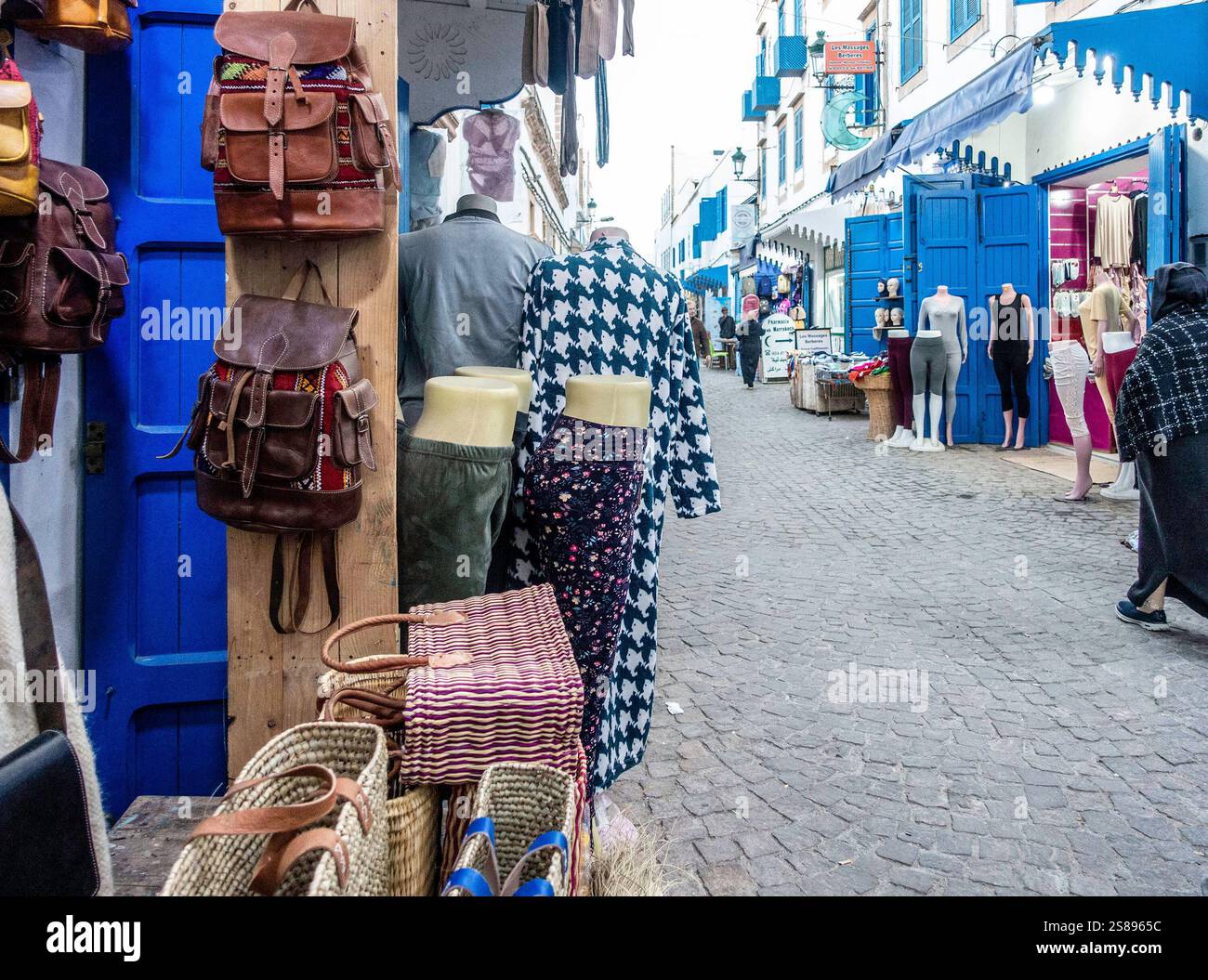 Der geschäftige Souk in Essaouira, Marokko, bietet farbenfrohe Stände und Einheimische, die in traditioneller Kleidung stöbern. Stockfoto