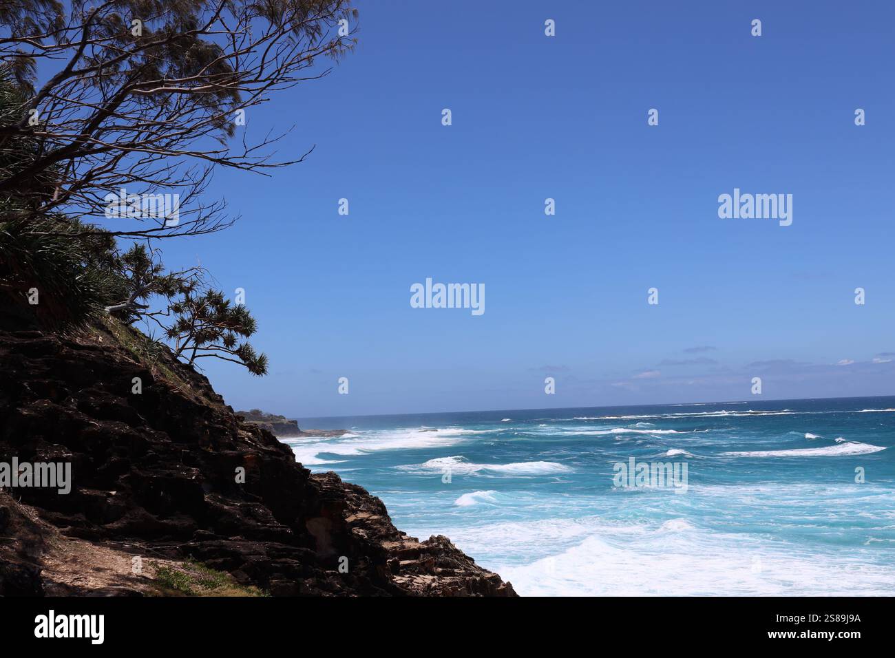 Grober Pinsel, felsige Punkte, blauer Himmel und tiefblaues Meer Stockfoto
