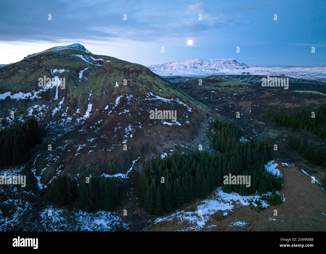 Aus der Vogelperspektive auf die Berge südlich des Lake Thingvellir in Island, den Monduntergang im Westen, die Winterlandschaft Stockfoto
