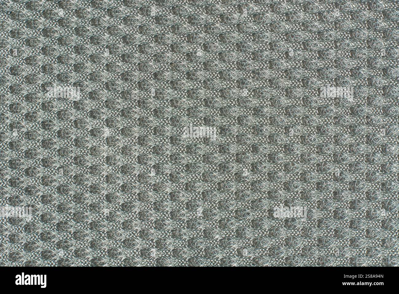 Nahaufnahme einer hellneutralen grauen Texturhintergrundfläche im Vollformat, erhöhtes, holpriges Raster wie abstraktes Muster Stockfoto