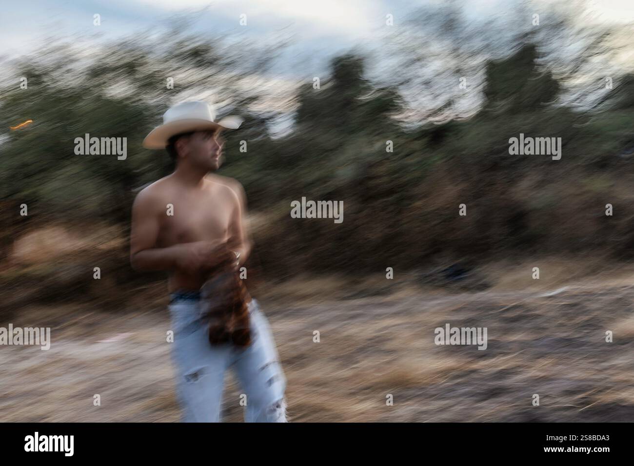 Vaquero Mexicano bereitet sich auf ein traditionelles Ranch-Leben in der Abenddämmerung in ländlicher Umgebung vor Stockfoto