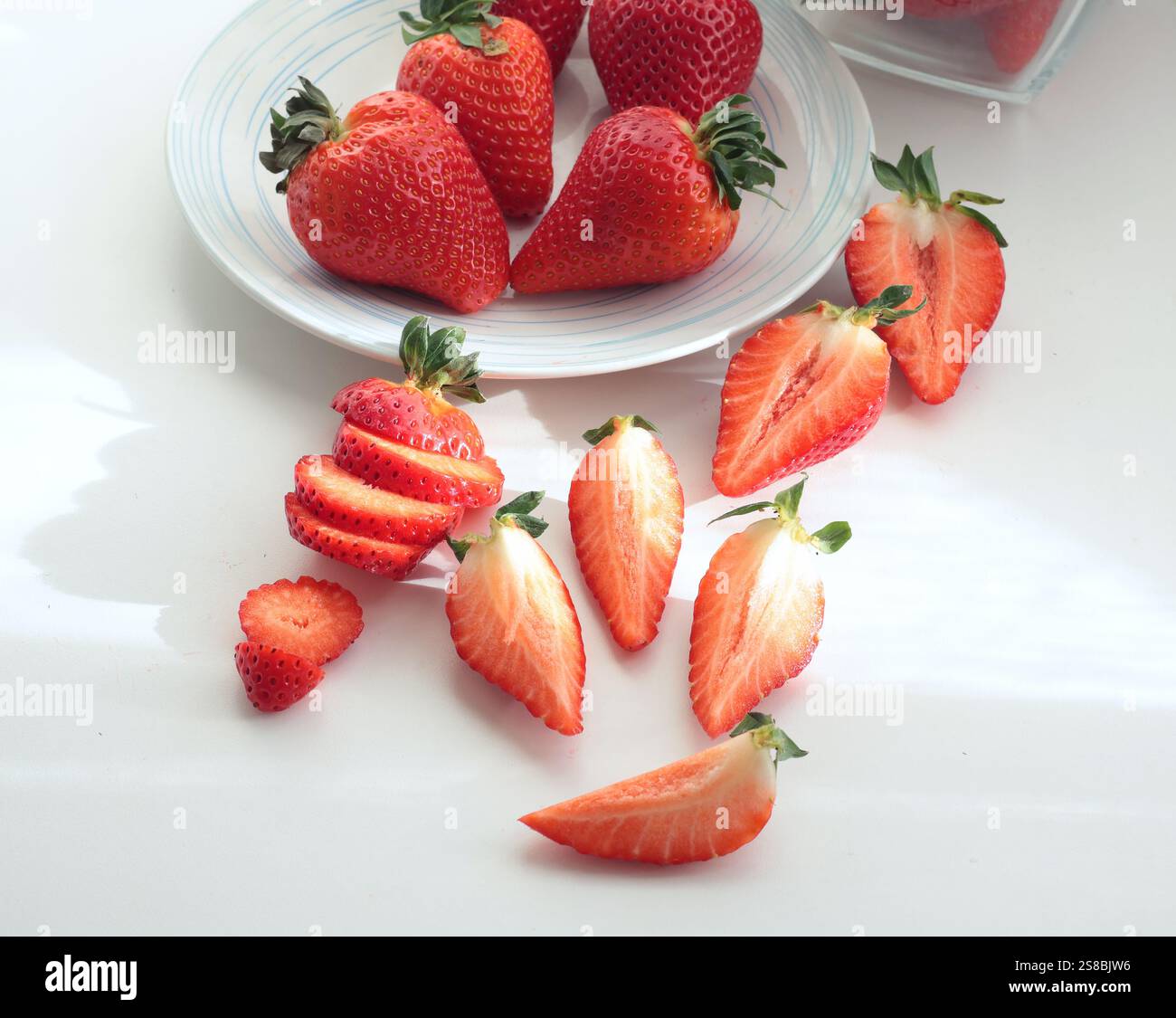 Gruppe geschnittener Erdbeeren aus dem Garten auf weißem Hintergrund. Umweltfreundliches reines Naturprodukt. Stockfoto