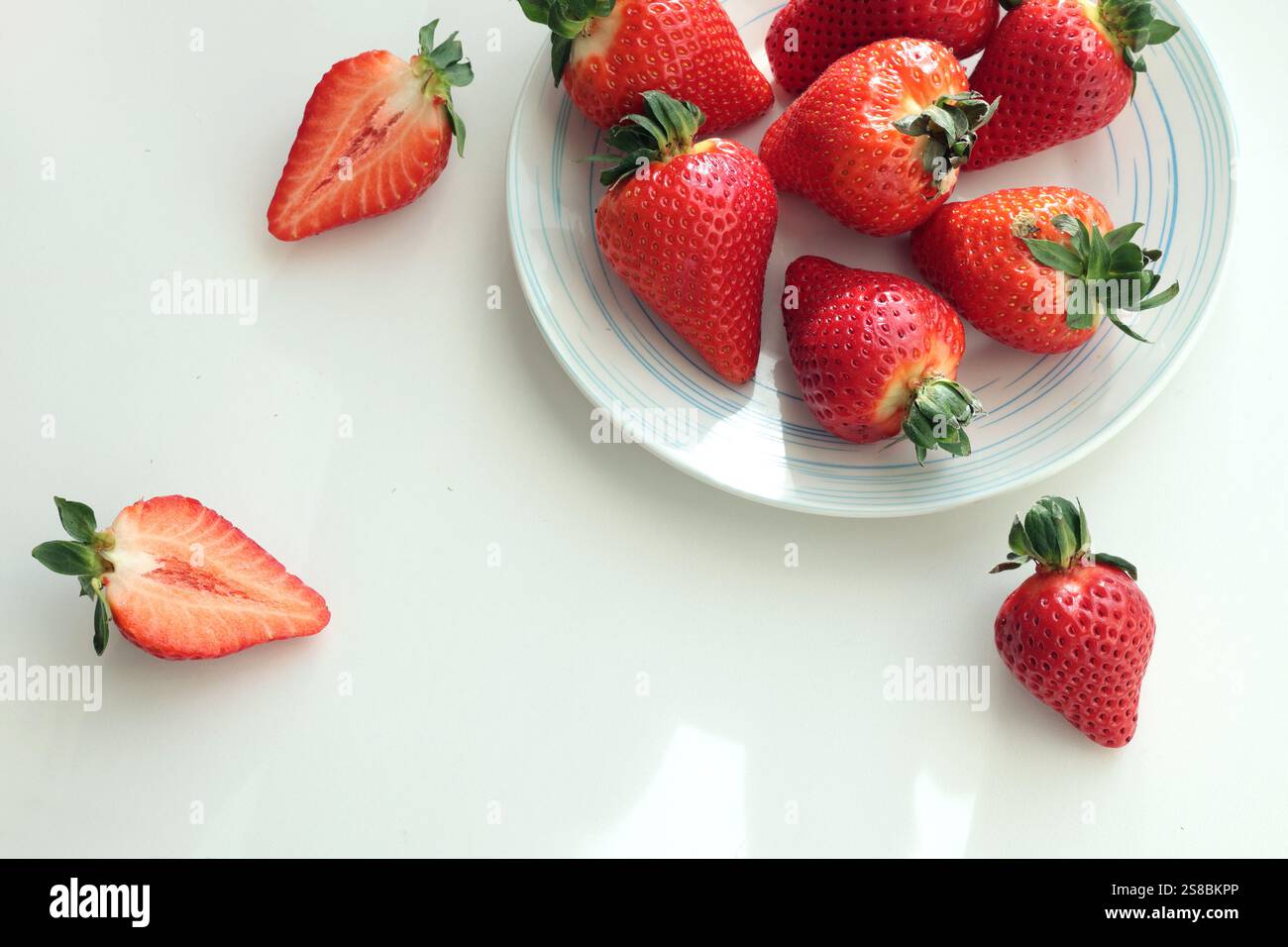 Gruppe von geschnittenen Erdbeeren aus dem Garten zu Hause auf Teller. Sonnentag. Umweltfreundliches reines Naturprodukt. Stockfoto