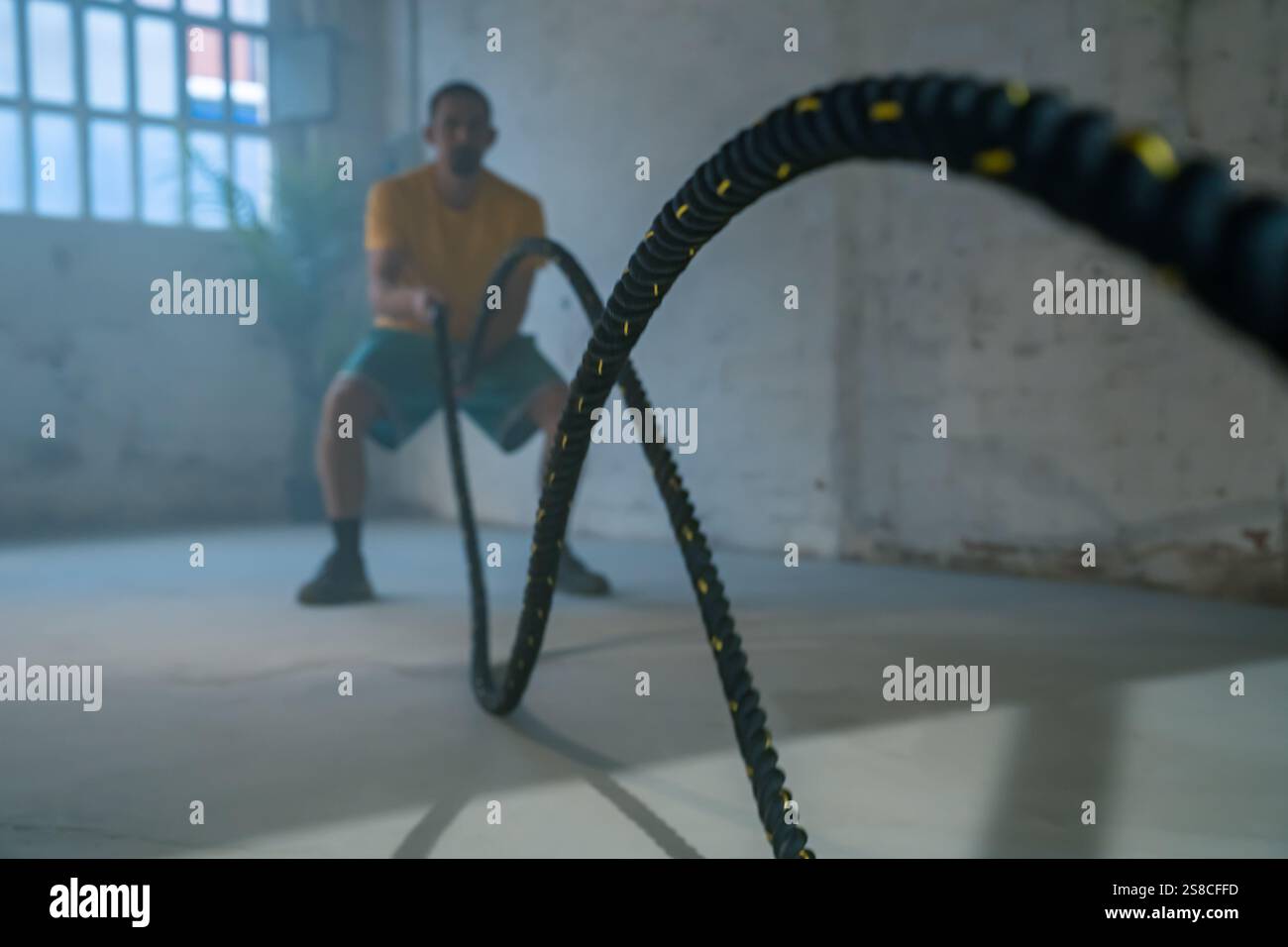 Fesselndes und dynamisches Battle Rope Workout in einer modernen urbanen Fitnessumgebung Stockfoto