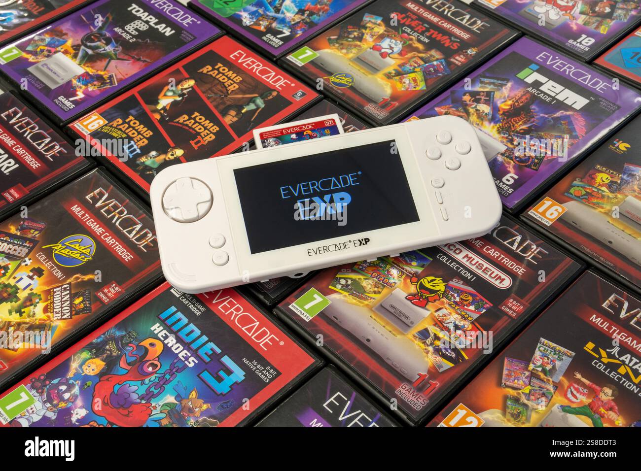 Eine Evercade EXP-Handkonsole mit dem Startup-Logo auf einem Bett mit Evercade-Spielkassette. Indie Heroes 3 Kartusche ist sichtbar. Stockfoto