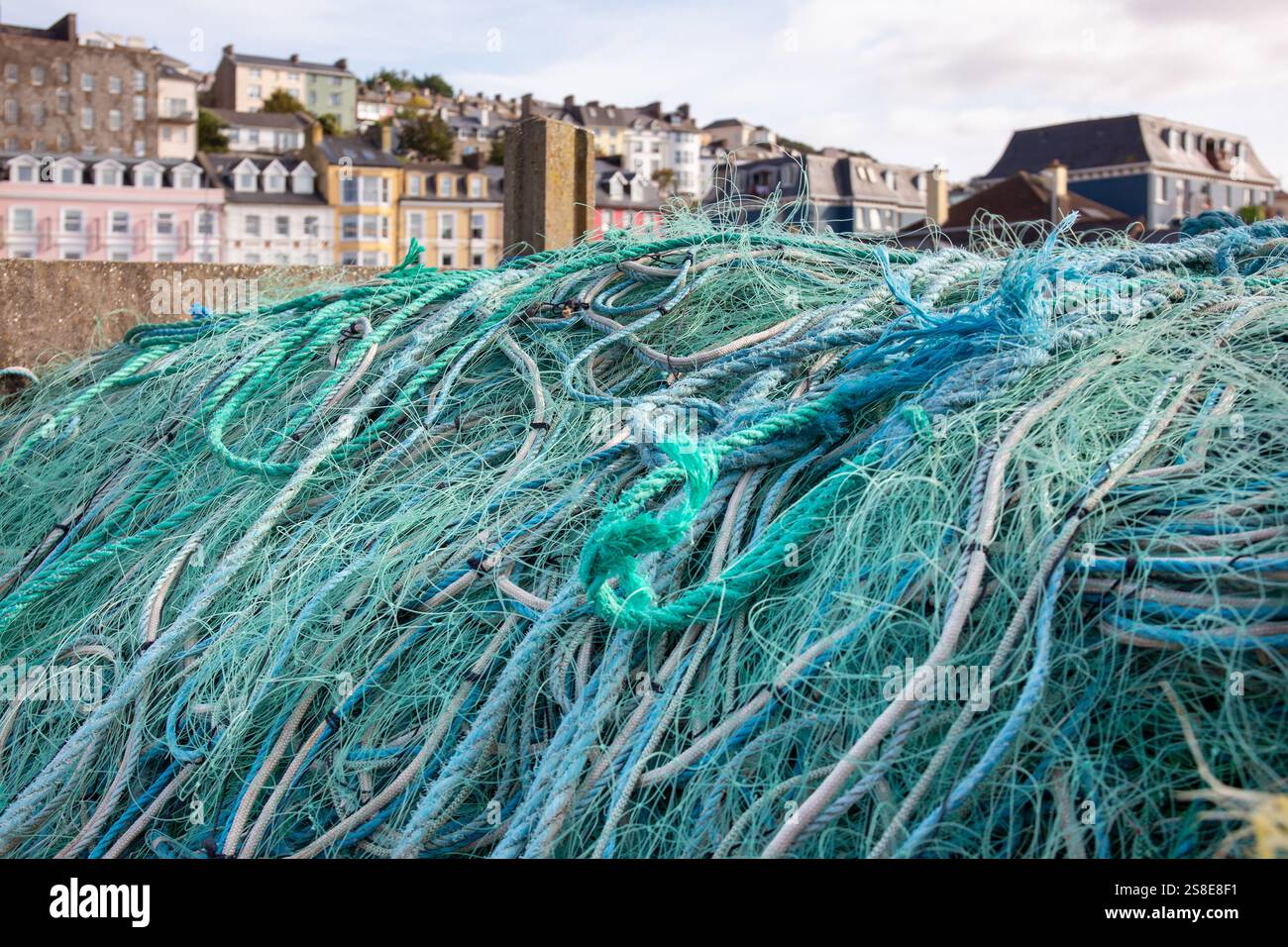 Grüne Fischernetze mit roten Wagen am Fischerhafen Stockfoto