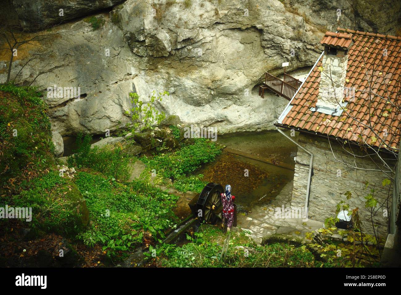 Safranbolu, Karabük, Türkiye : Eine Person in traditioneller Kleidung, die in einem Wassermühlenhaus an der felsigen Klippe auf dem Land steht Stockfoto