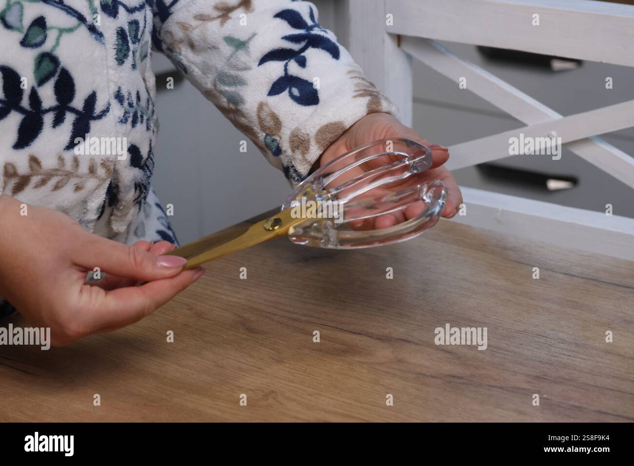 Eine Frau untersucht eine Schere. Sie ist dabei, ihren Kauf auszupacken und zu überprüfen. Nahaufnahme. Stockfoto