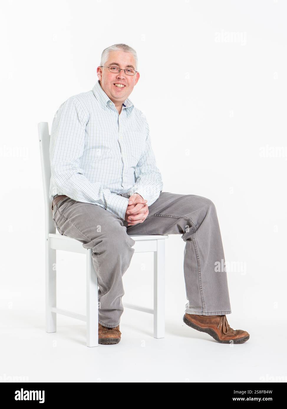 Entspannte und freundliche Körpersprache von einem lässig gekleideten Mann auf weißem Hintergrund. Stockfoto