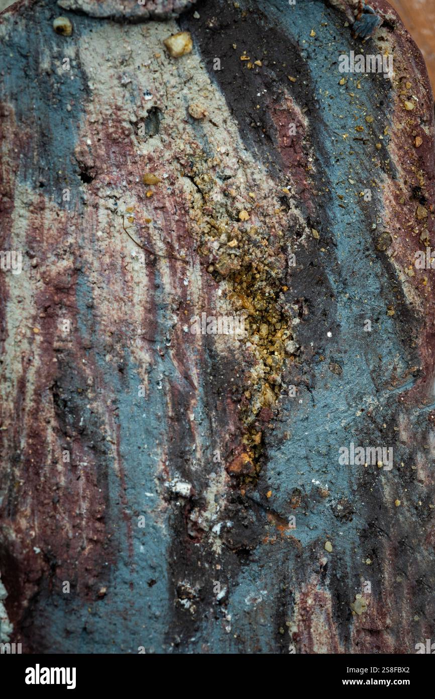 Nahaufnahme einer strukturierten Oberfläche mit abgenutzter Farbe in Erdfarben. Durch die Überlagerung von Schmutz und Farbe entsteht ein einzigartiges abstraktes Muster Stockfoto