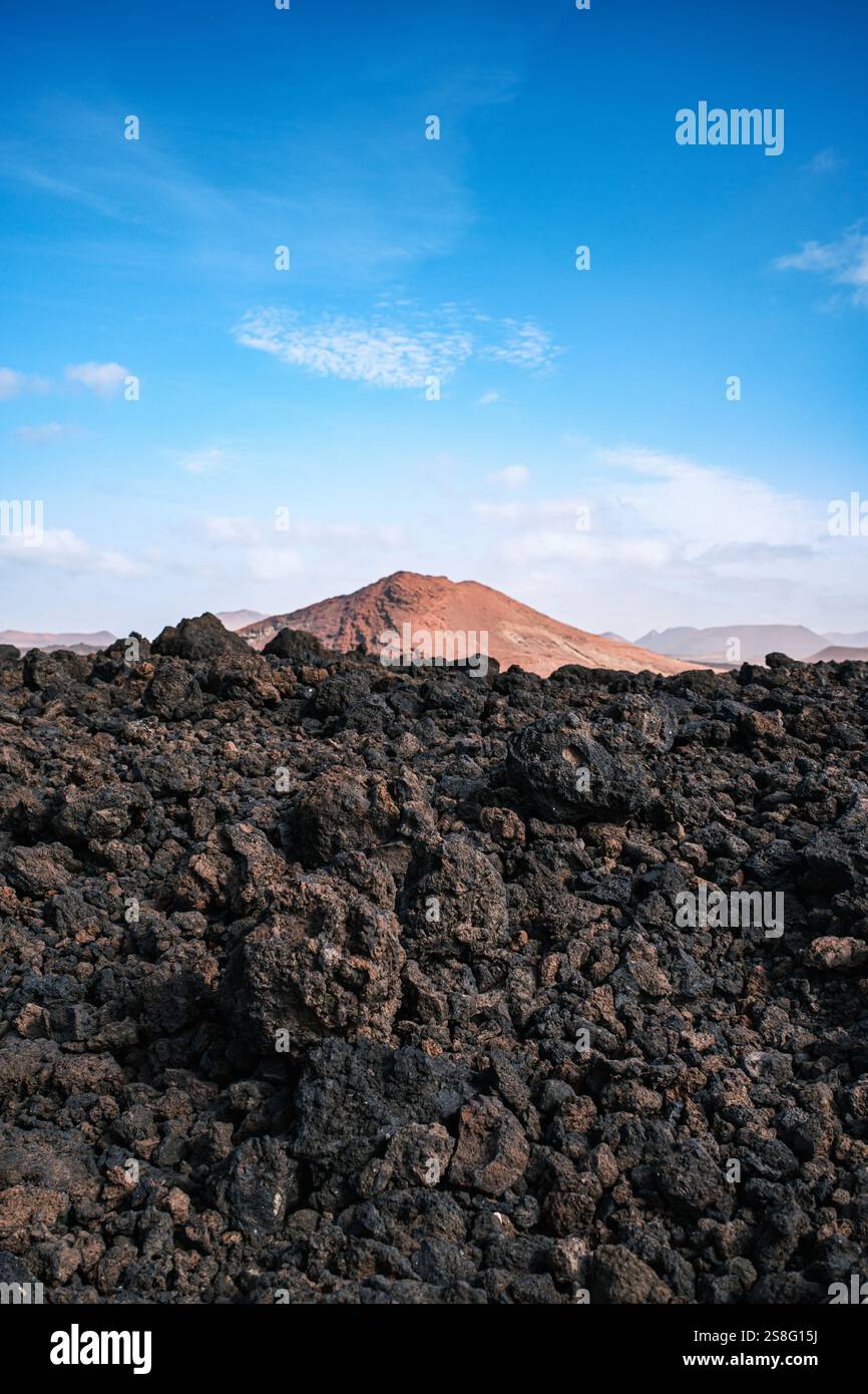 Atemberaubende vulkanische Landschaften mit schwarzem Sand, zerklüfteten Bergen und tiefblauem Himmel auf Lanzarote Stockfoto