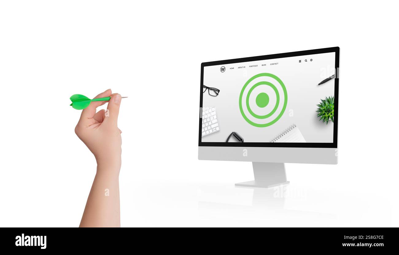 Halten Sie einen Pfeil mit der Hand, um auf einen Monitor zu zielen, der ein Ziel auf einer konzeptionellen Webseite anzeigt und damit Präzision, Strategie und zielorientiertes digitales Planen symbolisiert Stockfoto