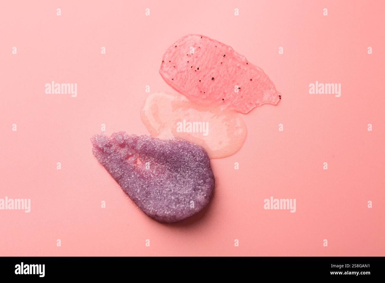 Abstriche von Körperpeelungen auf hellrosa Hintergrund, Draufsicht Stockfoto