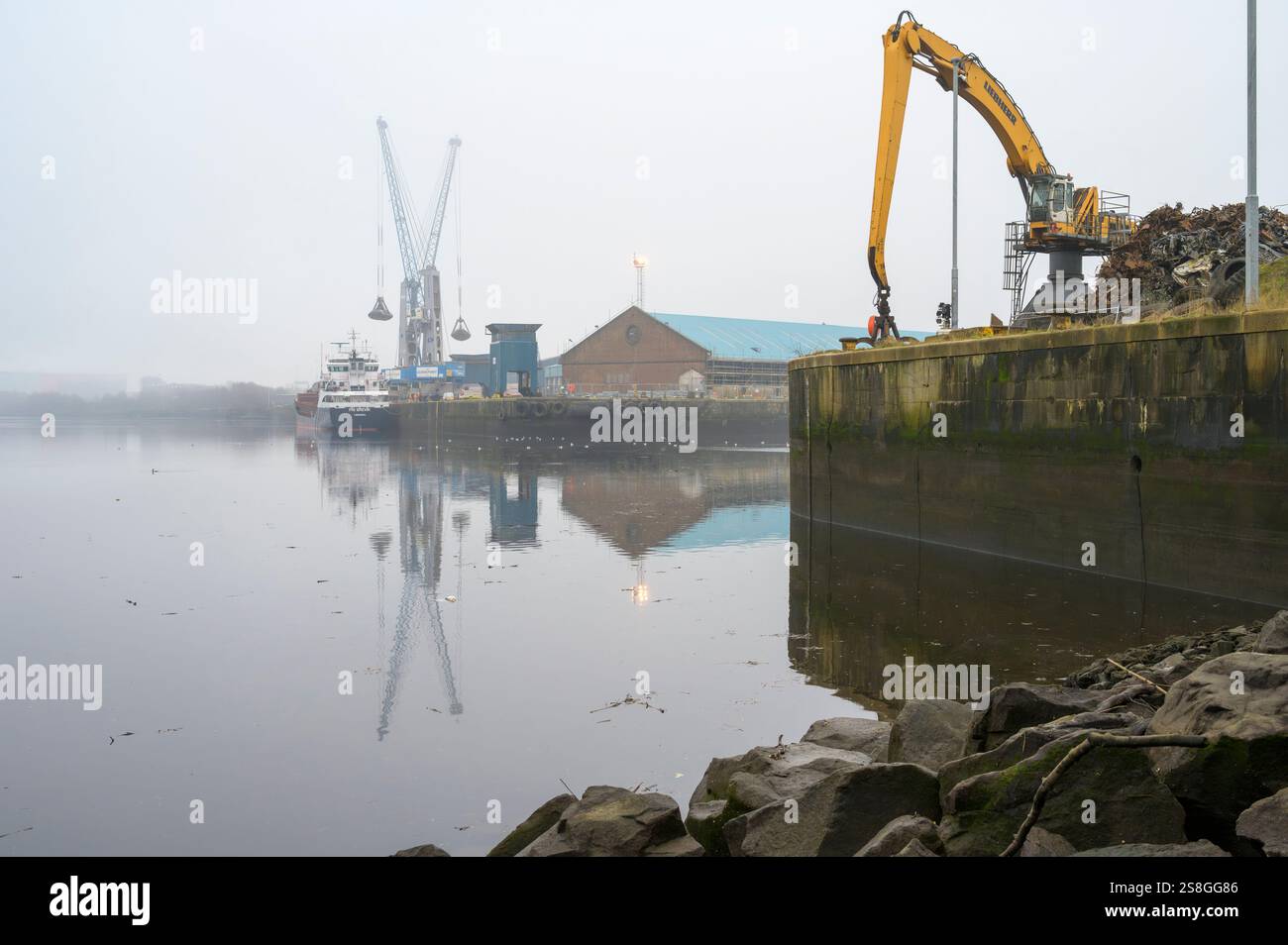 Dockside-Kranentladung vom Frachtschiff Fri Brevik an einem nebeligen King George V Dock, Glasgow, Schottland, Großbritannien, Europa Stockfoto