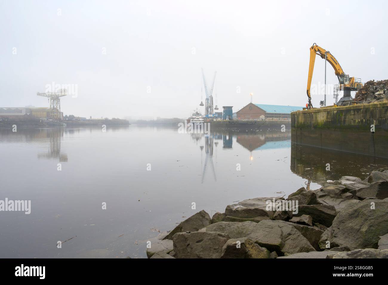 Dockside-Kranentladung vom Frachtschiff Fri Brevik an einem nebeligen King George V Dock, Glasgow, Schottland, Großbritannien, Europa Stockfoto
