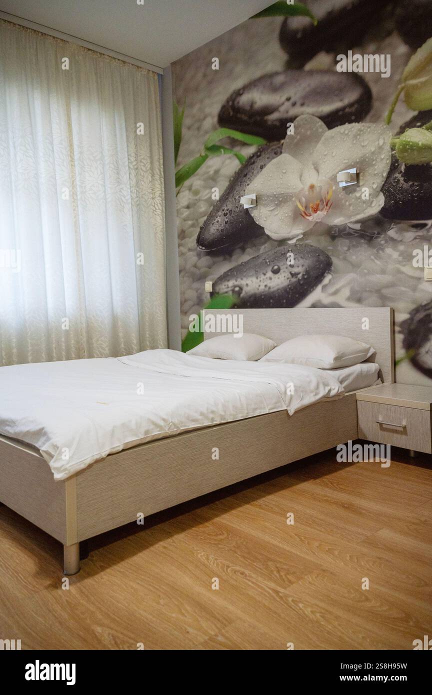 Doppelbett mit Kissen und Licht aus dem Fenster. Stockfoto
