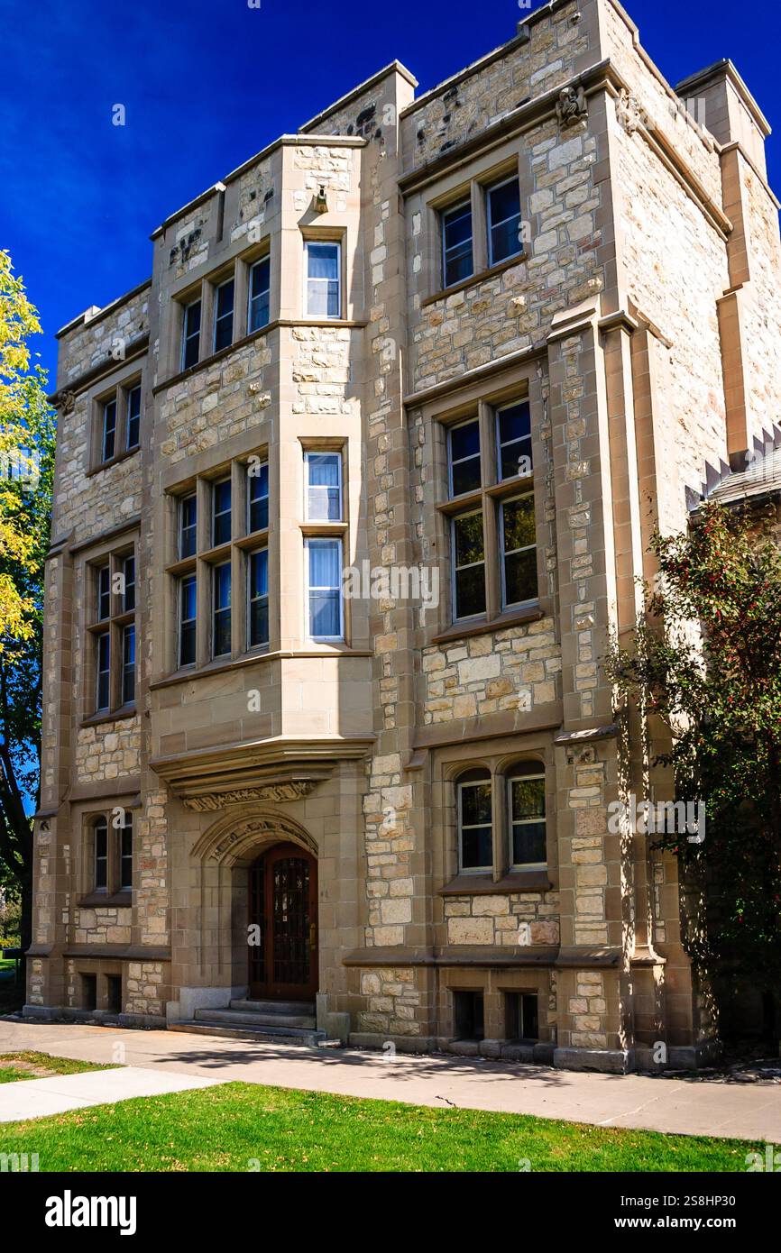 Ein großes Gebäude mit einer Steinfassade und einem großen Fenster. Das Gebäude ist hoch und hat viele Fenster Stockfoto