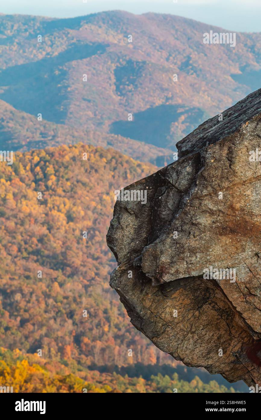 Die vertikale Aufnahme zeigt eine zerklüftete Felsformation, die von einem Berg ragt, mit hübschem Herbstlaub im Hintergrund, im Norden Georgiens Stockfoto