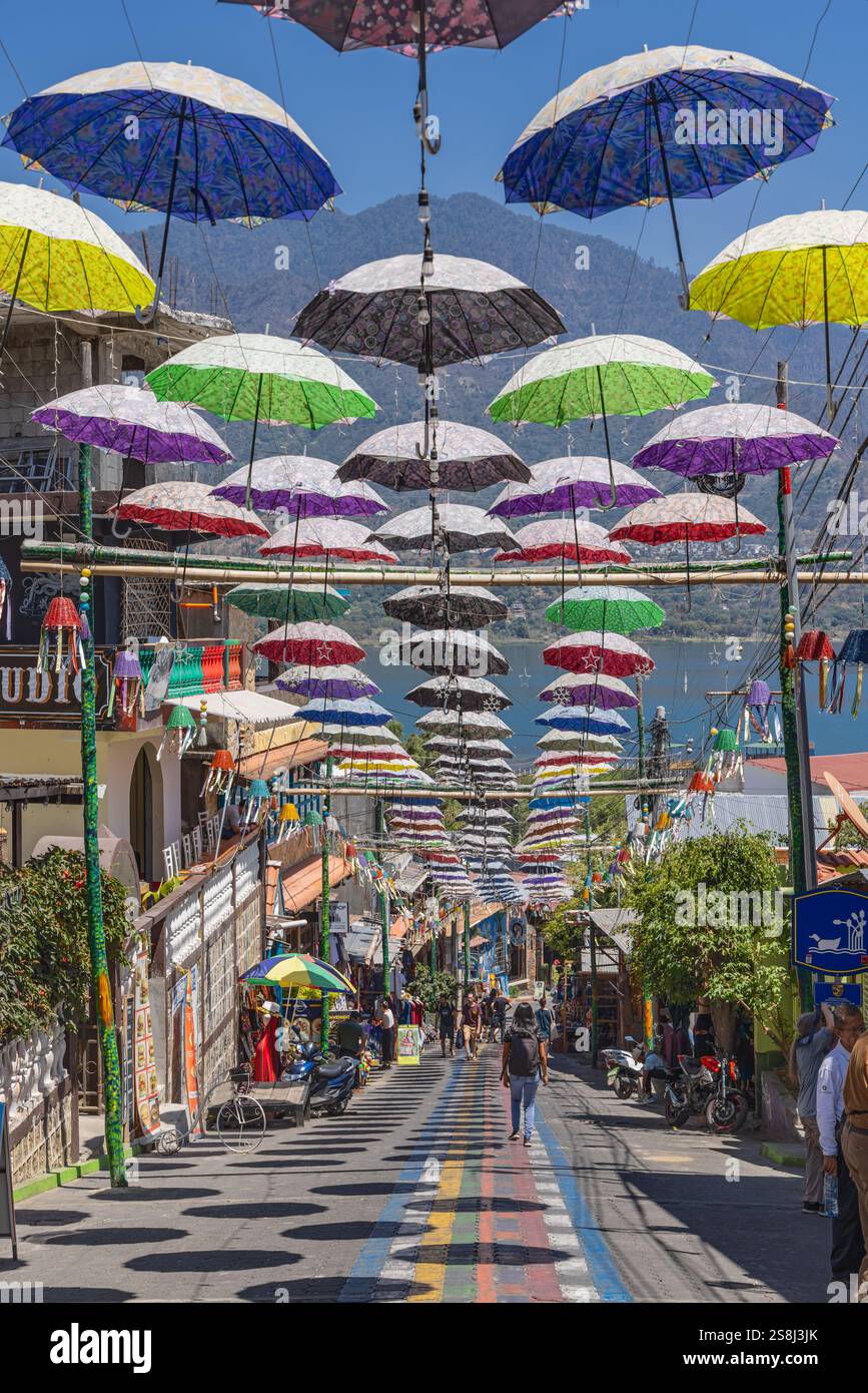 San Juan La Laguna, Solola, Guatemala. März 2024. Sonnenschirme über einer Straße in einer Stadt nahe Lake Atitlan. Stockfoto San Juan La Laguna, Solola, Guatemala. März 2024. Sonnenschirme über einer Straße in einer Stadt nahe Lake Atitlan. Stockfoto