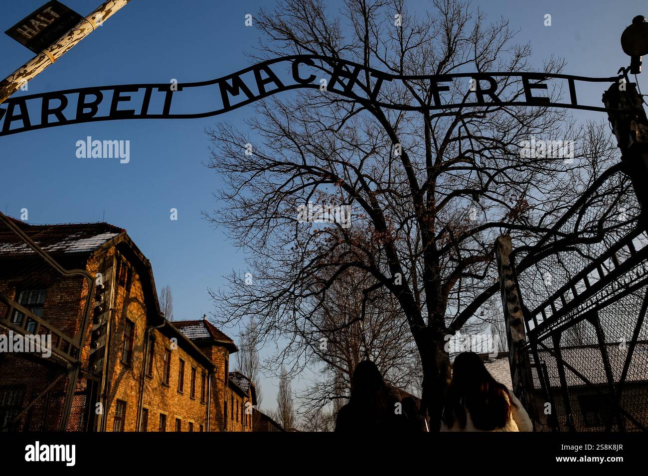 Oswiecim, Polen. Januar 2025. Besucher gehen am Haupttor vorbei mit dem berühmten Schild „Arbait Macht Frai“ (Arbeit macht Sie frei) des Konzentrationslagers Auschwitz/Birkenau Tage vor dem 80. Jahrestag der Befreiung des Konzentrations- und Vernichtungslagers Auschwitz am 27. Januar 2025. Quelle: SOPA Images Limited/Alamy Live News Stockfoto