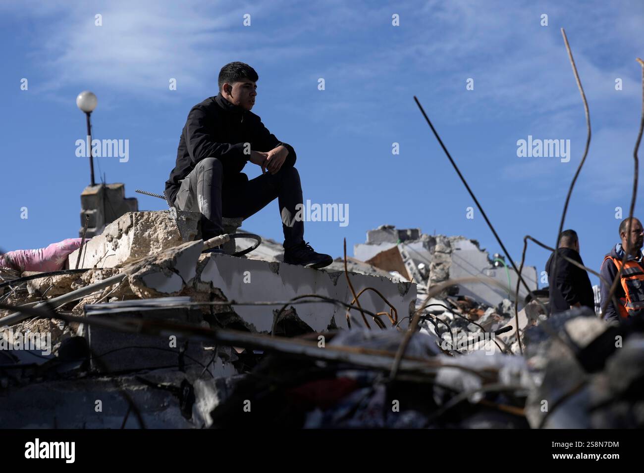 A Palestinian sits on the rubble at the site where Israeli forces ...
