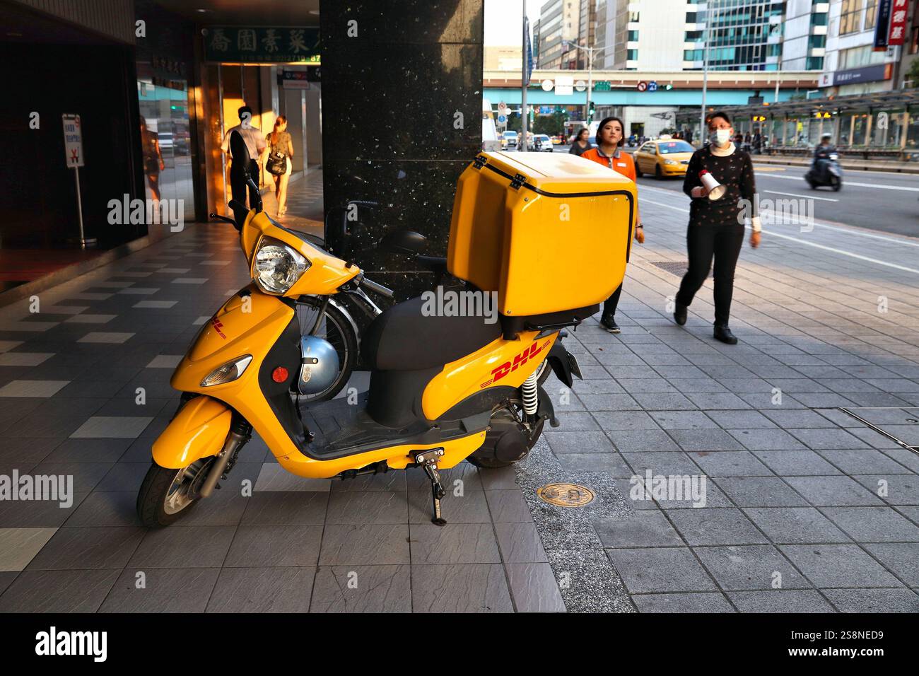 TAIPEI, TAIWAN - 4. DEZEMBER 2018: DHL-Kurierpaket für Motorräder im Stadtteil Xinyi, Taipei. Taipei ist die Hauptstadt Taiwans mit großer Bevölkerung Stockfoto