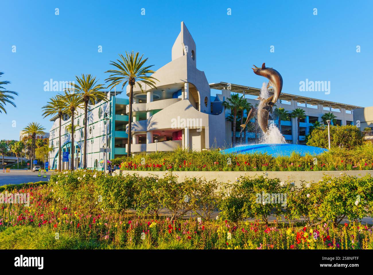 Long Beach, Kalifornien - 15. Januar 2025: Blick auf den Dolphin Fountain neben einzigartiger Architektur im Aquarium of the Pacific, eingerahmt von Palmen Stockfoto