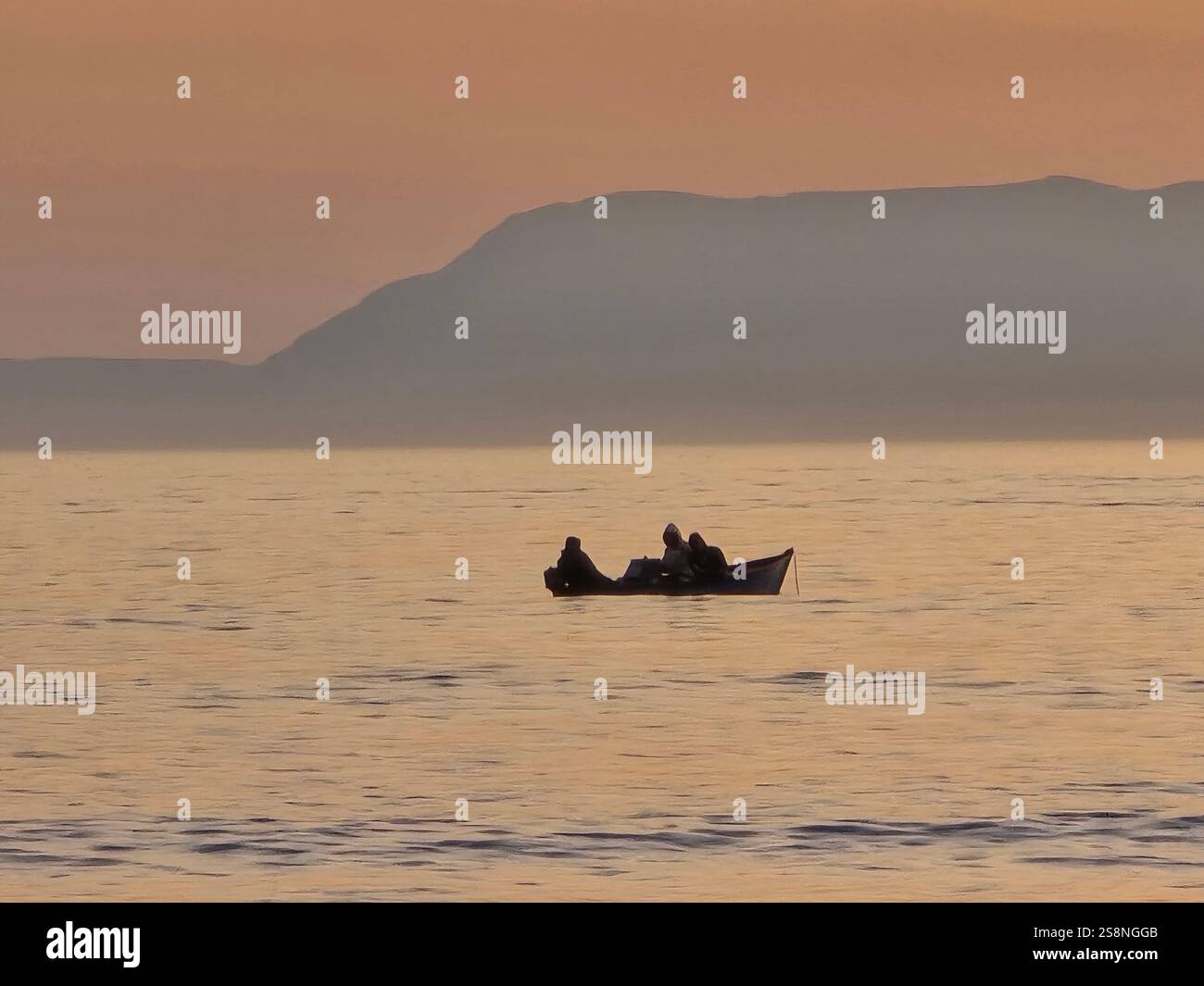Ein kleines Fischerboot zwischen den Wellen des Ozeans - Smartphone-aufgenommenes Stockfoto
