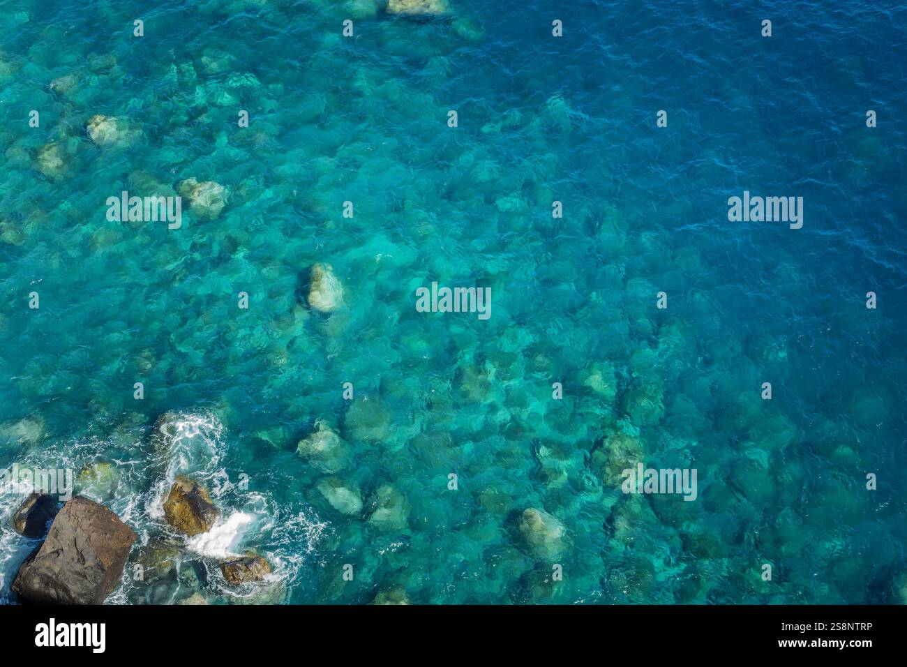 Blick auf die Felsen und das blaue, unberührte Meer mit klarem, transparentem Wasser. Ozeanhintergrund mit Kopierbereich Stockfoto