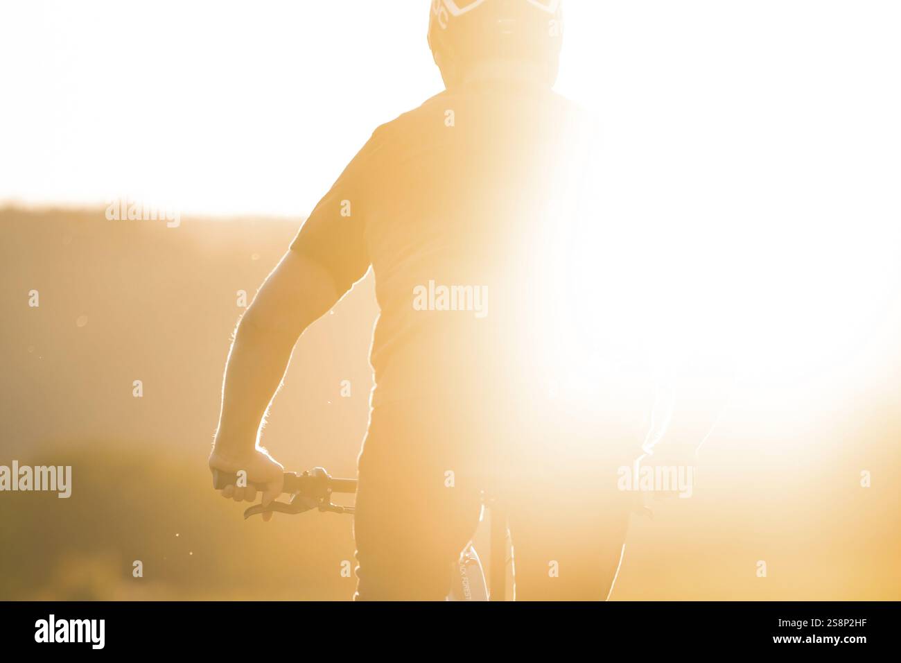 Person, die ein Fahrrad mit intensivem Sonnenlicht im Hintergrund fährt, E-Bike, Waldrad, Calw, Bezirk Calw, Schwarzwald, Deutschland, Europa Stockfoto