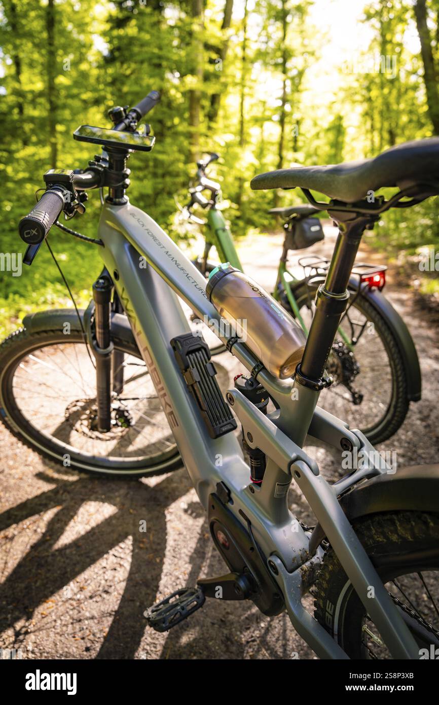 Zwei E-Bikes auf einem Waldweg, beleuchtet von Sonnenstrahlen im Hintergrund, E-Bike, Waldrad, Calw, Stadtteil Calw, Schwarzwald, Deutschland, Europa Stockfoto