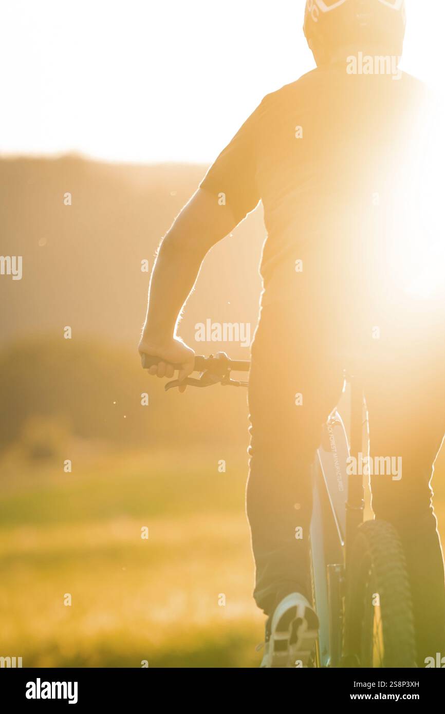 Silhouette eines Radfahrers bei starkem Sonnenlicht auf einer Feldpiste, E-Bike, Waldrad, Calw, Stadtteil Calw, Schwarzwald, Deutschland, Europa Stockfoto