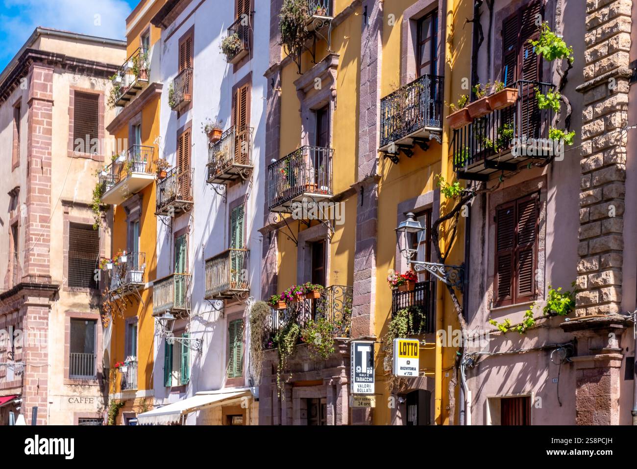 Touristen in einer Fußgängerzone, künstlerische Balkone und Blumenarrangements, Bosa, Europa, Provinz Oristano, Italien Stockfoto