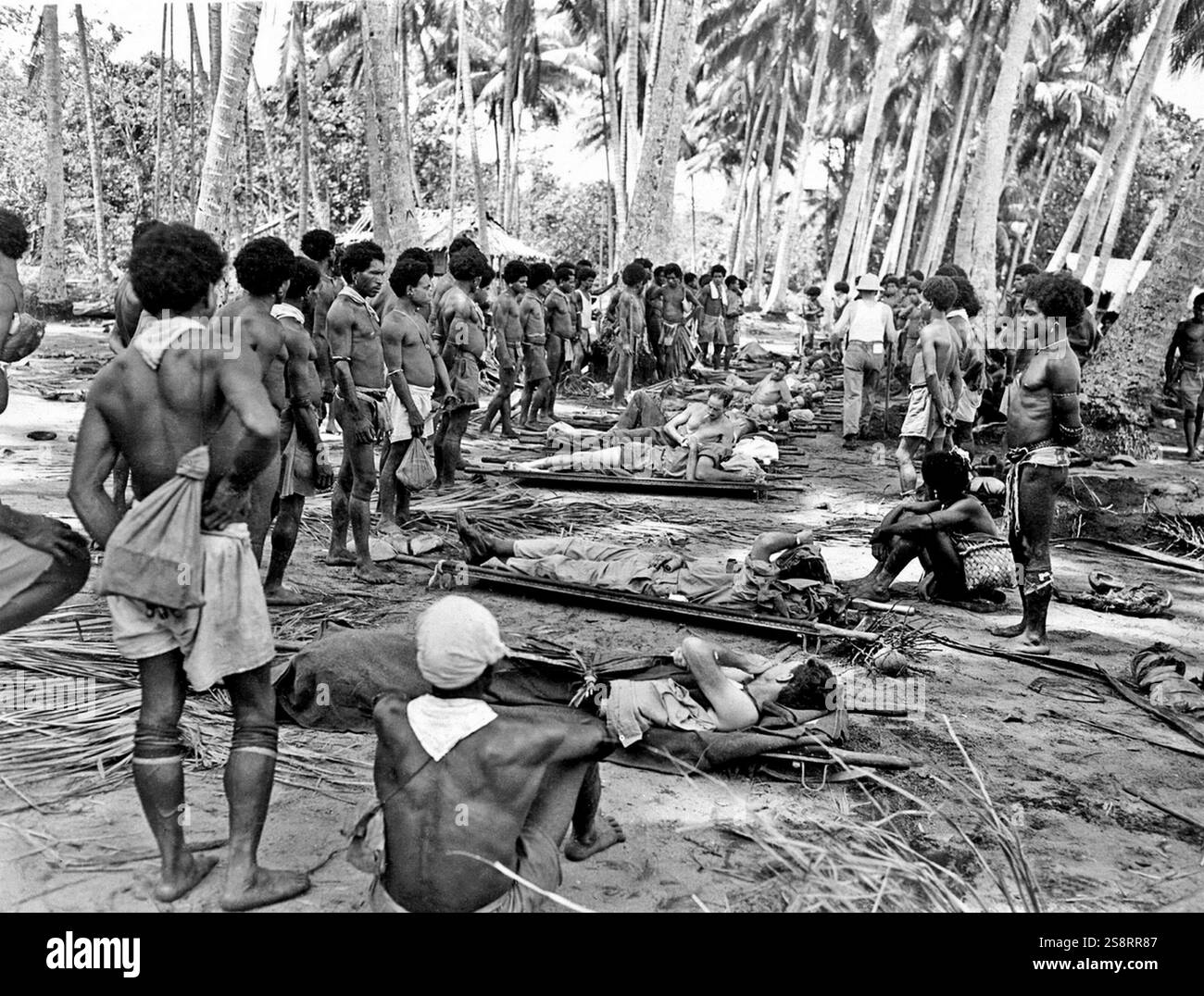 Verwundete amerikanische Soldaten der 32. Division werden von Papua-Neuguineas-Eingeborenen nach hinten getragen, die den Alliierten geholfen haben, indem sie Vorräte aufbrachten und Verwundete zurückbrachten. Während des Zweiten Weltkriegs war der Feldzug von Neuguinea (1942–1945) einer der wichtigsten militärischen Feldzüge und Konflikte zwischen Japan und den Alliierten. Etwa 216.000 japanische, australische und US-amerikanische Soldaten starben Stockfoto