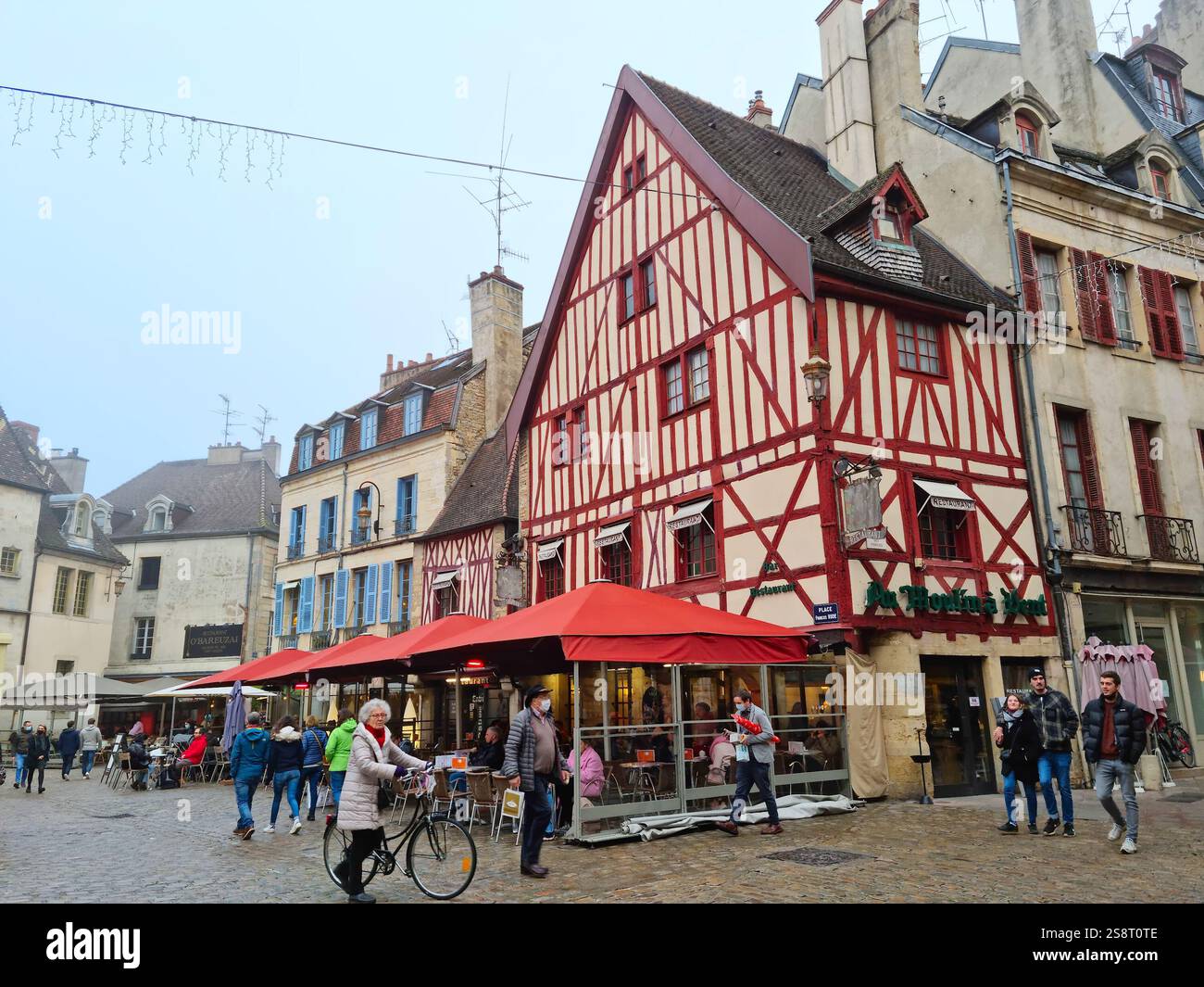 Dijon, Frankreich - 31. Dezember 2022: Menschen, die während der Weihnachtszeit auf dem Francois Rude Square spazieren gehen. Die Architektur ist eine Mischung aus Mittelalter und Renai Stockfoto