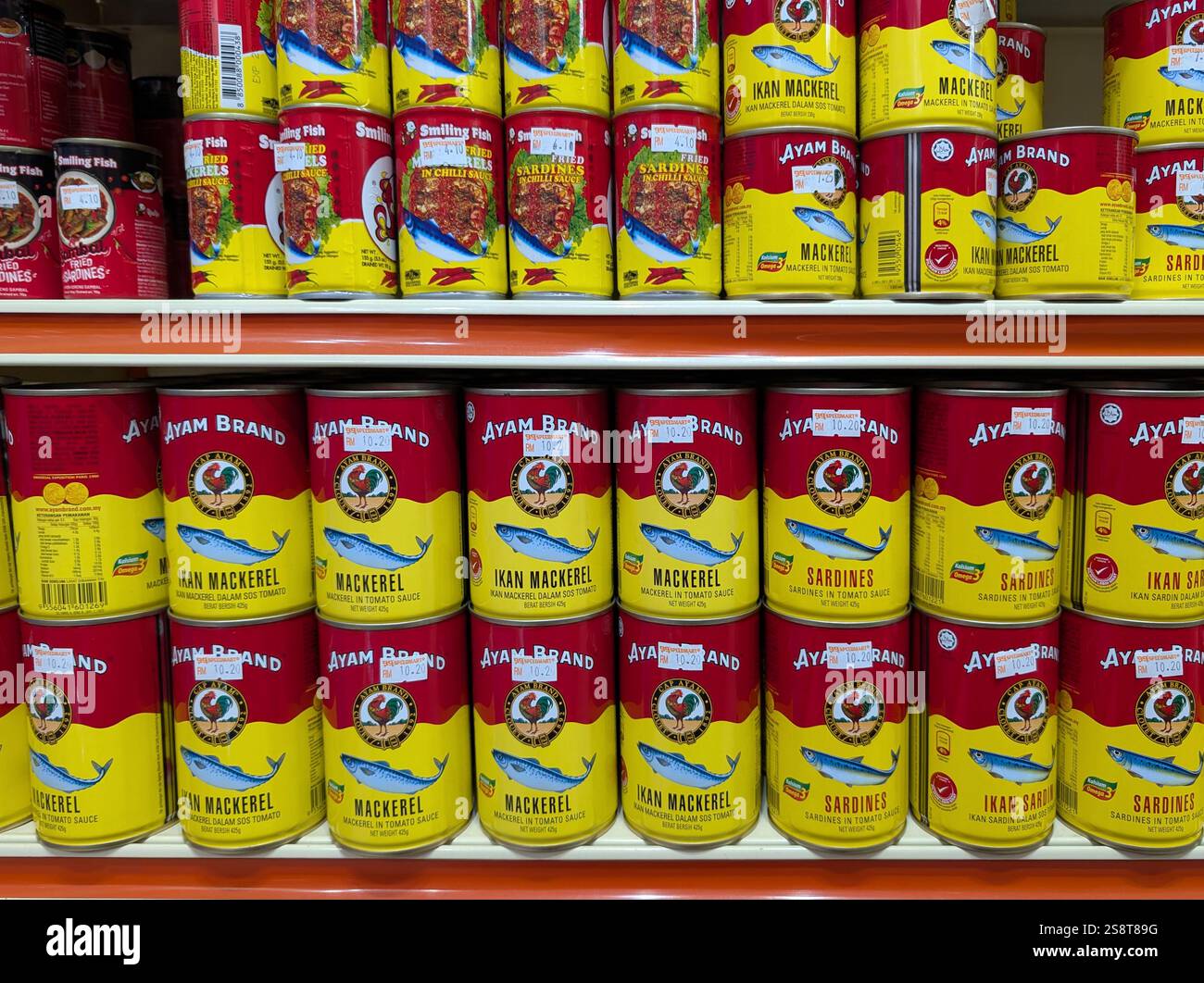 Kota Kinabalu, Malaysia - 20. Januar 2025: Makrele und Sardine von Ayam Brand in einem Einzelhandelsregal im Supermarkt. - Smartphone-aufgenommenes Stockfoto