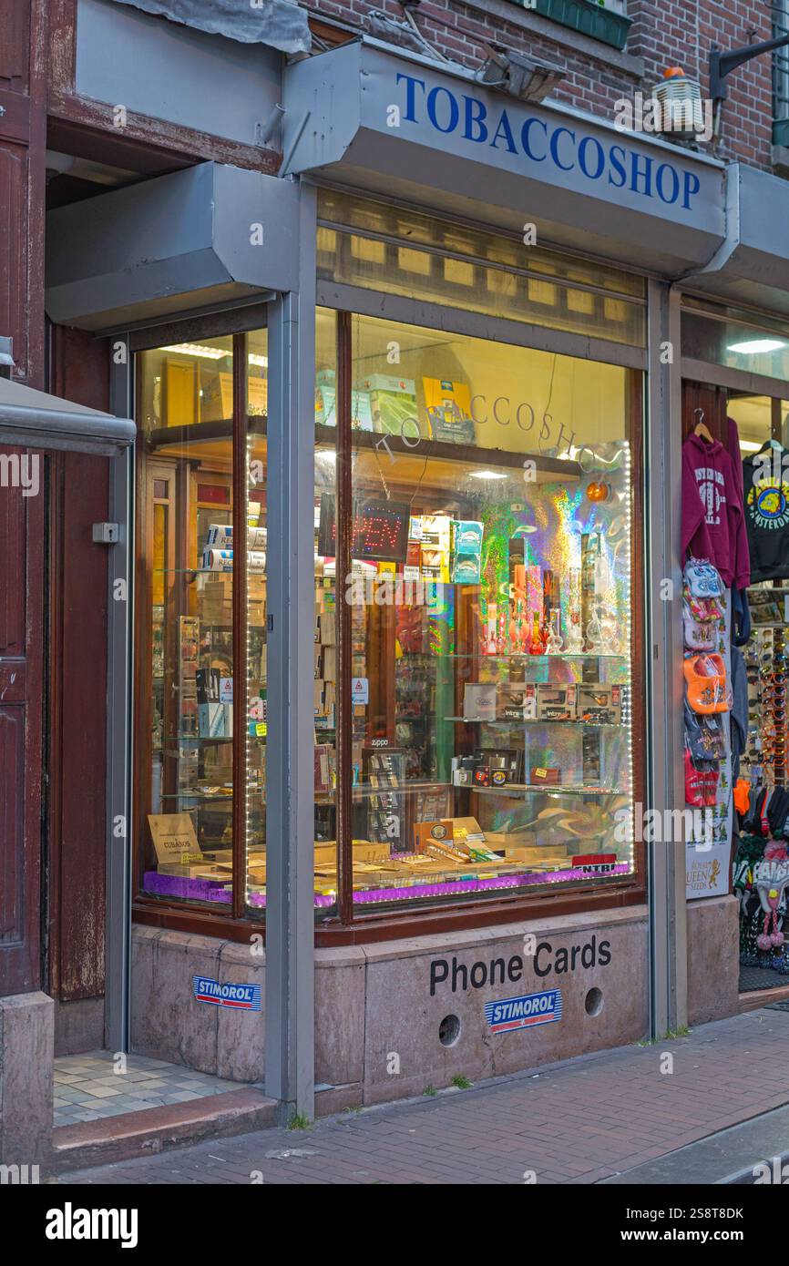 Amsterdam, Niederlande - 18. Mai 2018: Beleuchtetes Fenster im Tobacco Shop Zigarettenpfeifen Kaugummi Telefonkarten Store. Stockfoto