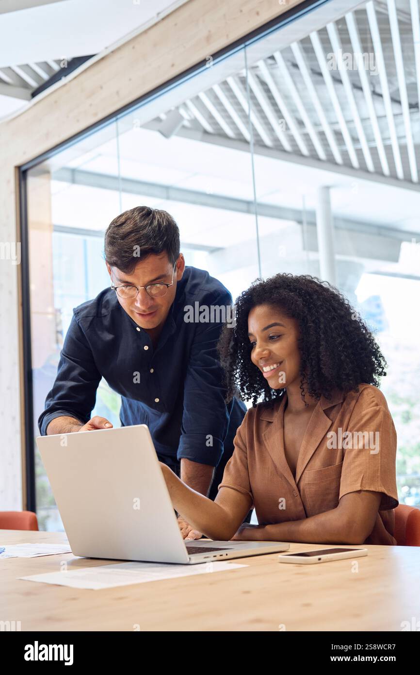 Viel beschäftigter Unternehmensleiter berät Mitarbeiter, die Unternehmenssoftware im Büro erlernen. Stockfoto