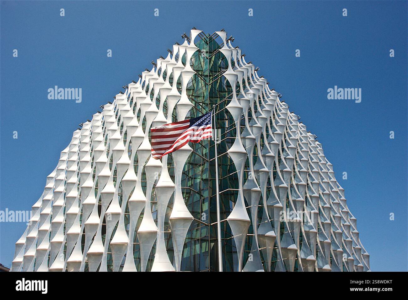 Die markante Glas- und Stahlfassade der US-Botschaft in London mit einzigartigen geometrischen Paneelen unter einem klaren blauen Himmel im Nine Elms District Stockfoto