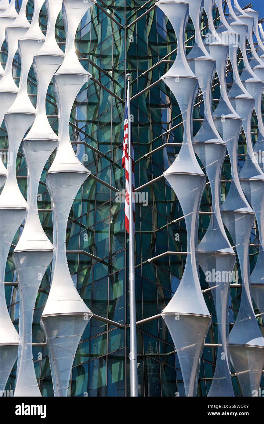 Die markante Glas- und Stahlfassade der US-Botschaft in London mit einzigartigen geometrischen Paneelen unter einem klaren blauen Himmel im Nine Elms District Stockfoto