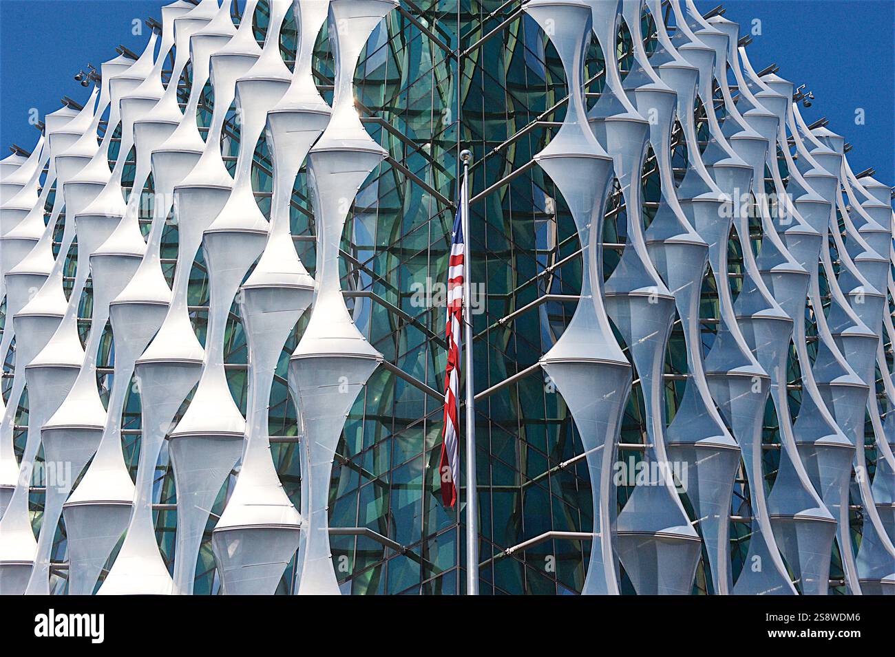 Die markante Glas- und Stahlfassade der US-Botschaft in London mit einzigartigen geometrischen Paneelen unter einem klaren blauen Himmel im Nine Elms District Stockfoto