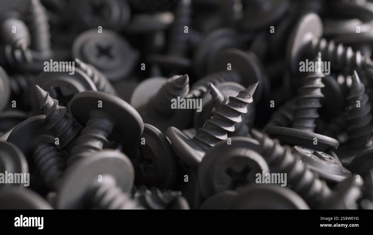 Nahaufnahme detaillierter Hintergrund von Metallschrauben für den Hintergrund industrieller Hardware. Makrofotografie mechanischer Befestigungselemente. Das Konzept für den Bau, Stockfoto